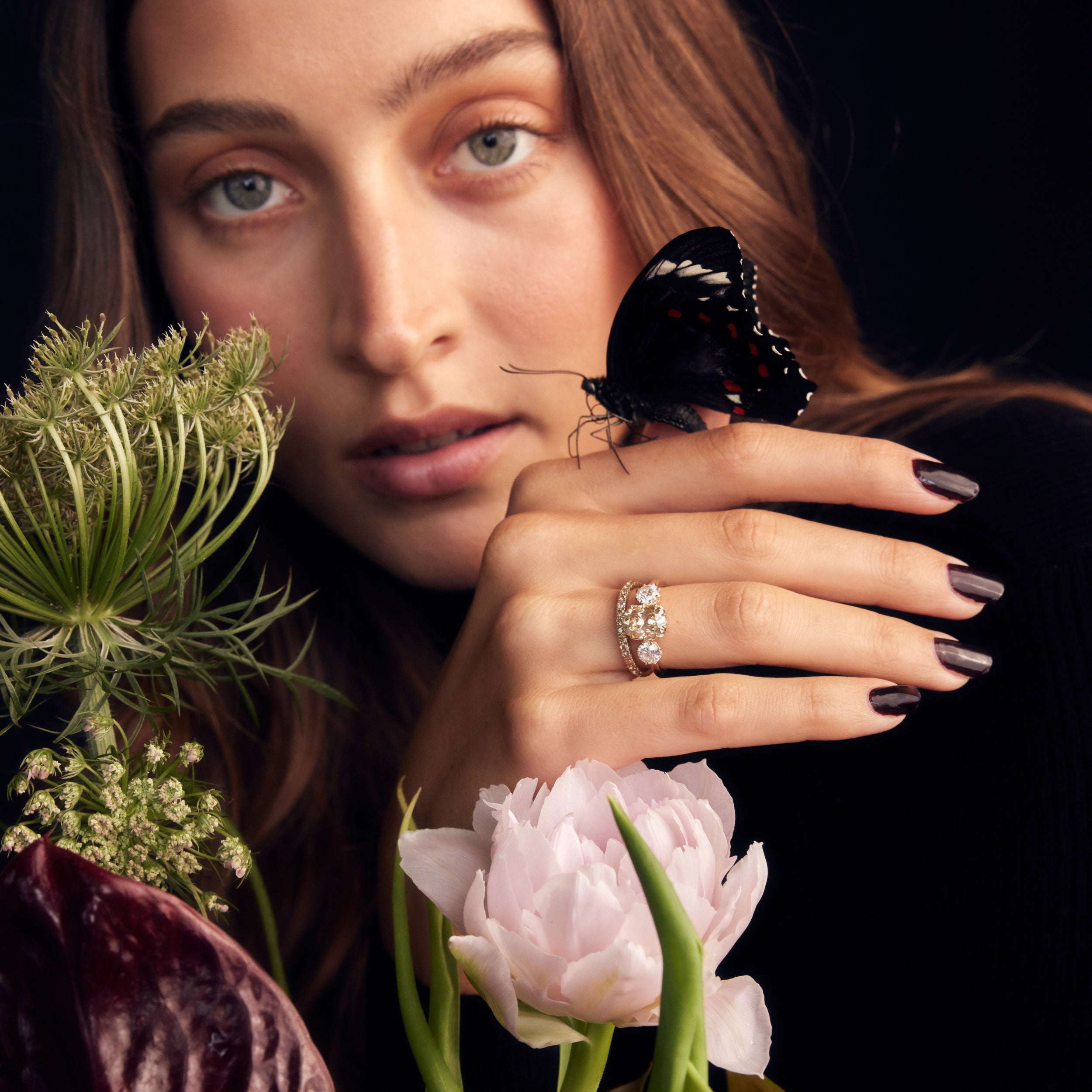 Champagne old mine cut three stone engagement ring trilogy ring with champagne moissanite pave wedding band holding butterfly